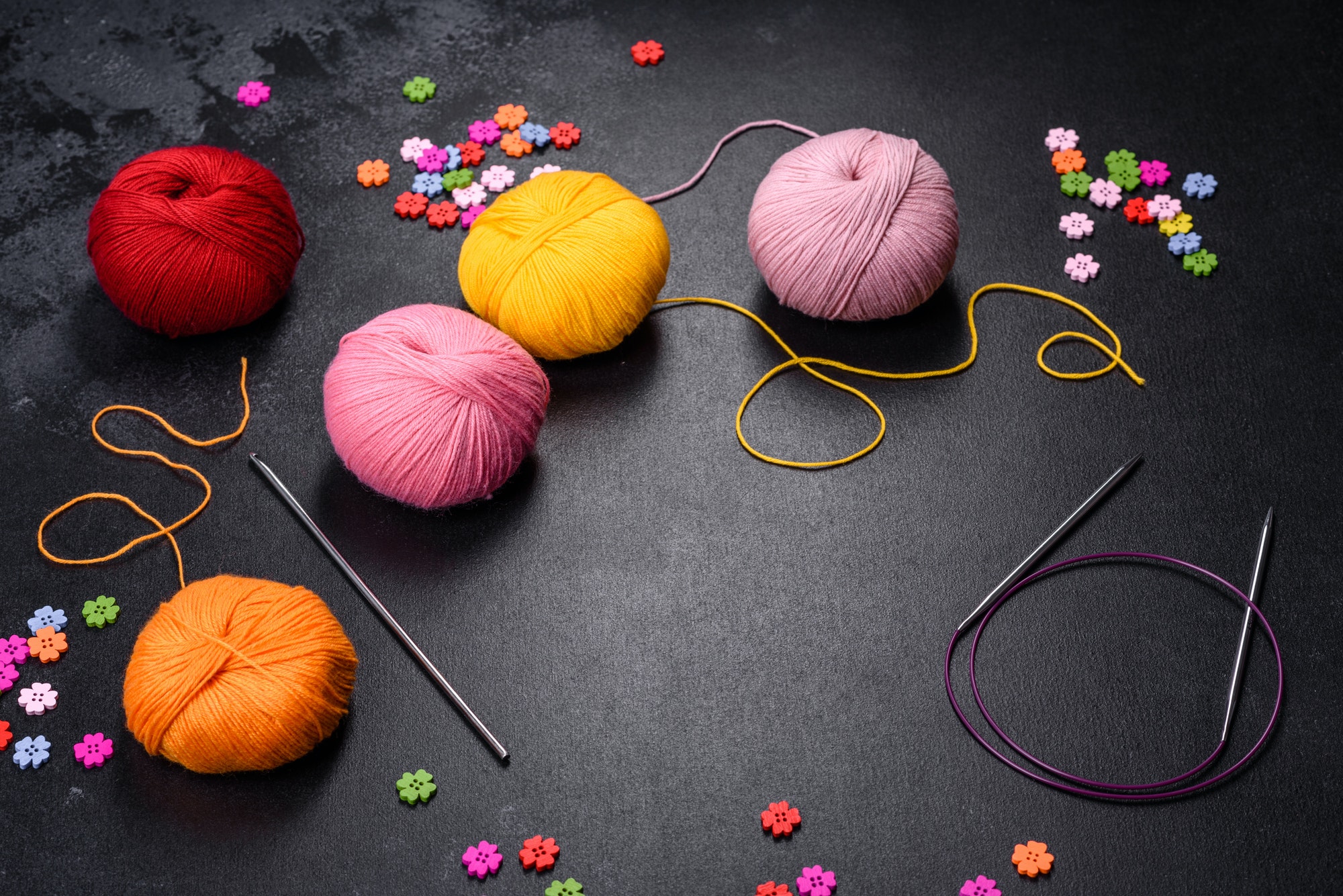 Colorful balls of wool on concrete table. Variety of yarn balls